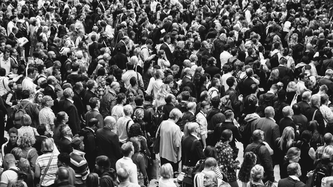 grascale photo of people standing on ground\